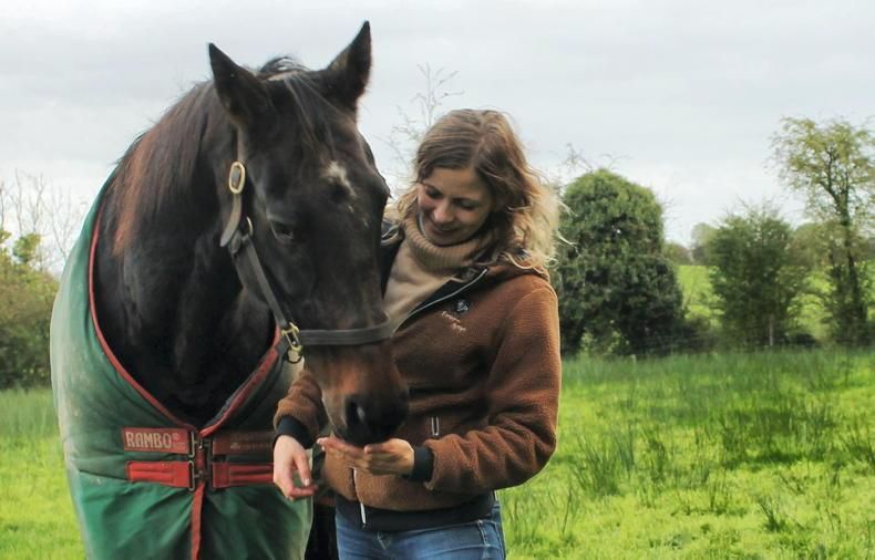 Owner of IF Equine Therapies and horse standing in a field